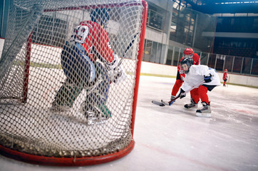 hockey goals, shoots the puck and attacks goalkeeper.