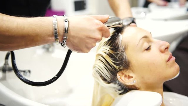 A young beautiful woman getting her hair washed at hairdresser’s, 4K