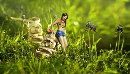 Creative beautiful toned photo manipulation with a girl near the giant shoe with a ladybug in the middle of a grass field with blue flowers