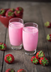 glass of strawberry smoothie and fresh strawberries .