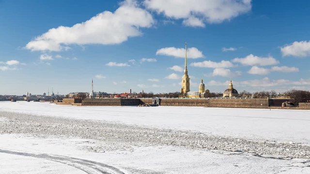 Scenic view of the Peter and Paul Fortress and the Neva River, covered with snow and ice. Winter sunny day, blue sky with clouds. Saint-Petersburg, Russia.