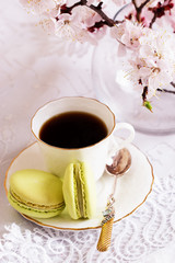 macaroons and a cup of coffee on a table. Sweet macarons and flowers