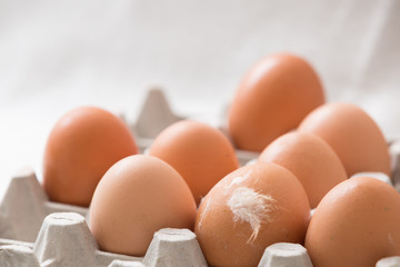 Preparations for Easter. Many light brown eggs in a paperbox.