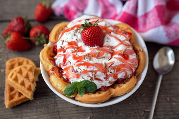 Golden waffle with strawberries and cream.