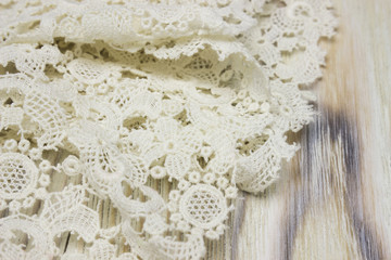 White vintage Irish cotton crochet lace on wooden background