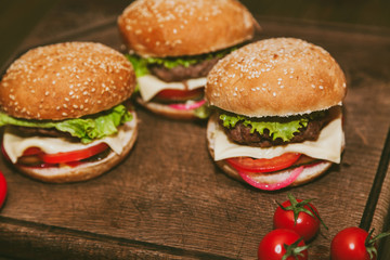 Burgers on a board with tomatoes