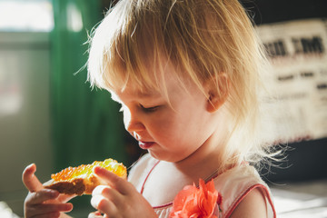 Little girl is eating a sandwich with caviar
