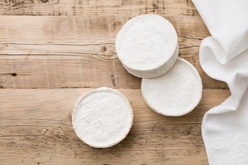 Top view on Camembert cheese on wooden board. Serving French homemade soft cheese. Food concept