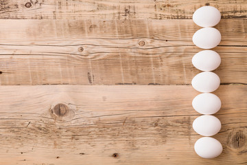 Top view on white eggs on a wooden background. Easter festive background. Flat lay.
