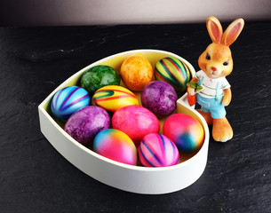 Fototapeta na wymiar Sugar rabbit and easter eggs on stone grey