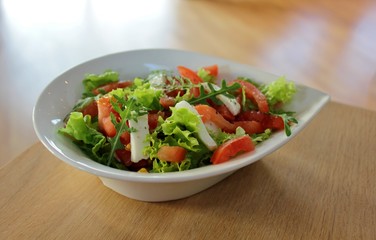 Bowl with Italian caprese salad with lettuce, mozzarella  and tomato