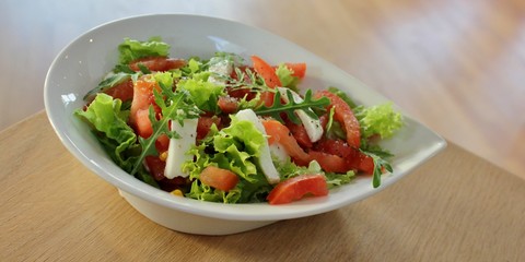 Bowl with Italian caprese salad with lettuce, mozzarella  and tomato
