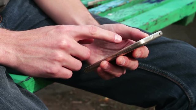 Young man Playing on mobile phone, looking at screen