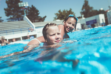 Underwater fun. Two cute little girls with goggles swimming underwater and diving in the swimming poll. Kids sport and leisure.