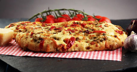 Hot pizza slice with melting cheese on a rustic wooden table.