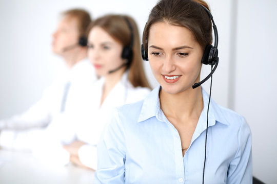 Call center. Focus on beautiful business  woman in headset.