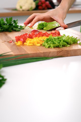 Close up of  woman's hands cooking in the kitchen. Housewife slicing ​​fresh salad. Vegetarian and healthily cooking concept