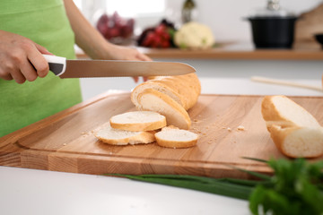 Close up of  woman's hands cooking in the kitchen. Housewife slicing ​​white bread. Vegetarian and healthily cooking concept