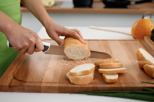 Close up of  woman's hands cooking in the kitchen. Housewife slicing ​​white bread. Vegetarian and healthily cooking concept