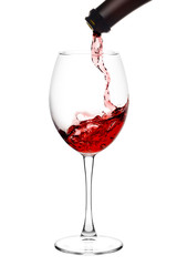 red wine poured from a bottle into wineglass on white background, isolated