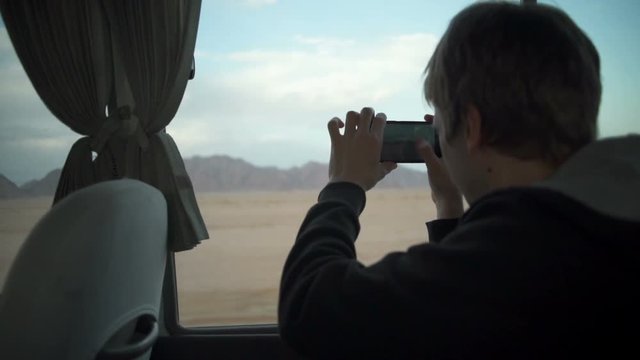 Man holding his phone and taking photo of a mountain slow motion