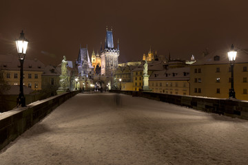 Night snowy Prague Lesser Town with Bridge Tower and St. Nicholas' Cathedral from Charles Bridge, Czech republic