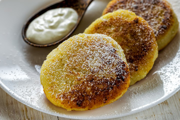 A dish of fried syrup with sour cream on a white plate