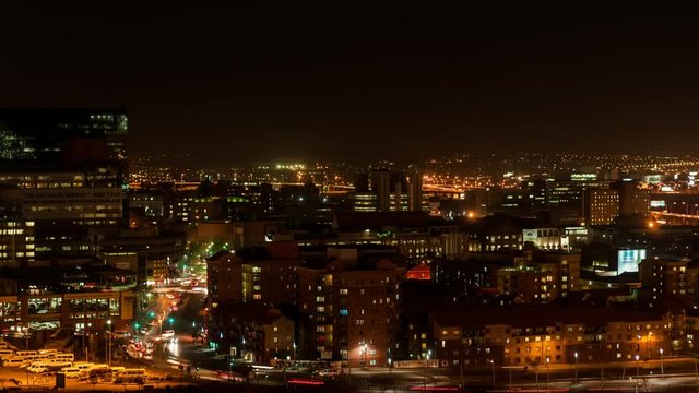 Night timelapse panning across the city centre of Johannesburg during peak traffic with streets and buildings, South Africa