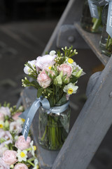 bouquet of lisianthus, roses and carnations on the steps of the staircase as decoration of the entrance to the house