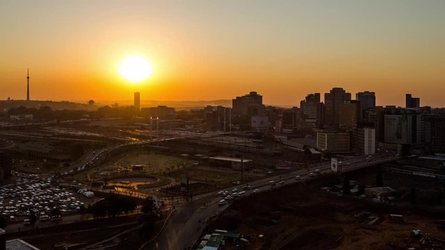 Static timelapse at sunset of the city centre (CBD) of Johannesburg overlooking the Nelson Mandela bridge from day to night transition, peak traffic, trains, cars, people and flickering lights.South Africa