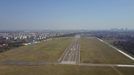 Propeller airplane taking off from airport runway on a sunny day, aerial shot