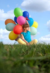 Happy child playing with colorful toy balloons outdoors