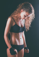 Portrait of young beautiful fitness woman, isolated on black background