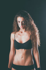 Portrait of young beautiful fitness woman, isolated on black background