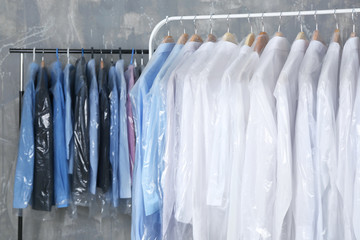 Rack of clean clothes hanging on hangers at dry-cleaning
