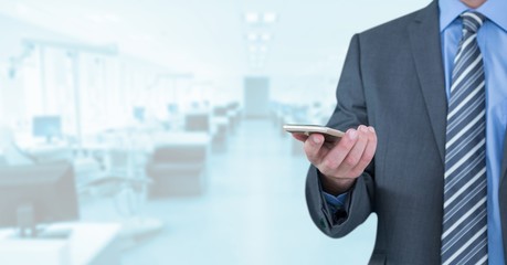 Businessman with phone in bright office