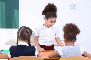 Beautiful elementary schoolgirls studying in classroom