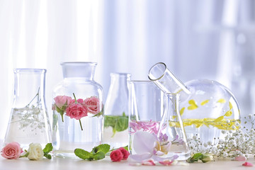 Beautiful composition with perfume samples and flowers on table