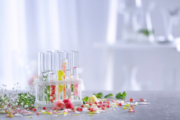 Beautiful composition with perfume samples and flowers on table