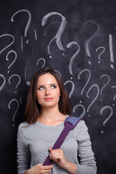 Young girl with question mark on a gray background