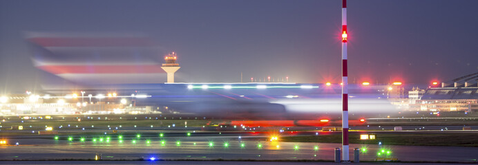 airplane starting speed blur at an airport at night