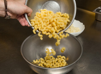 cooked Macaroni pasta being transferred to a meal bowl