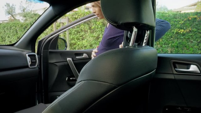 Pregnant woman with contractions entering car