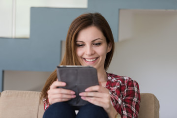 Fototapeta premium woman sitting on sofa with tablet computer