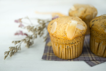 Homemade banana cup cake with sliced almond on wood background