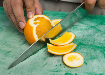 A juicy orange being sliced into segments. © dannyburn