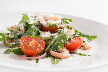salad of fresh vegetables with prawns dressed with olive oil and balsamic vinegar and sprinkled with grated cheese