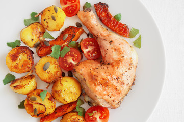 chicken leg roasted with potato and pumpkin served with tomatoes, cilantro, and pumpkin seeds