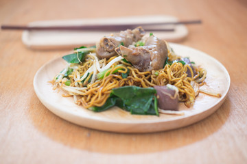 Thai style chicken noodles on the retro wooden table