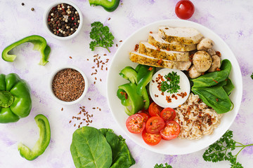 Diet menu. Healthy lifestyle. Oatmeal porridge,  chicken fillet and fresh vegetables - tomatoes, spinach, paprika,  mushrooms and yogurt  on plate. Top view. Flat lay.